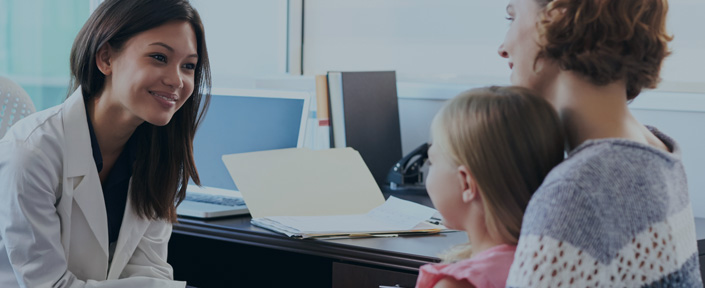 photo of a mother & daughter meeting with a doctor in an office