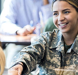 Female soldier shaking hands with another female.