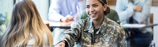 Female soldier shaking hands with another female.