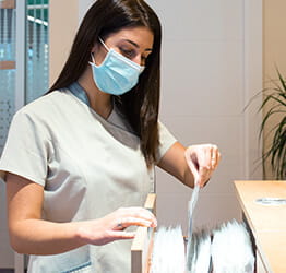 Image of woman adding papers to filing cabinet.