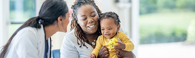 Image of doctor talking to woman holding toddler.