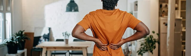 "Ways to Keep Your Back Healthy" article image. Image of man stretching and holding his back.