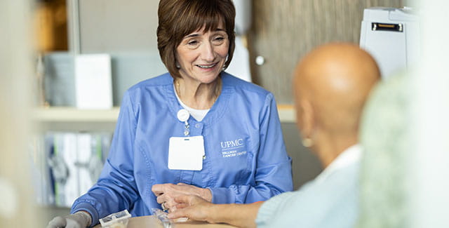 Photo of a UPMC nurse speaking with a patient.