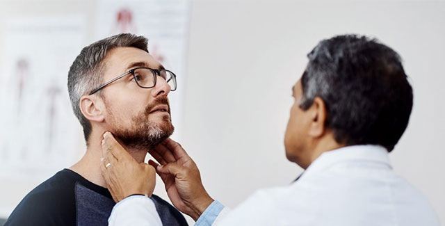 Photo of doctor examining patient's neck.