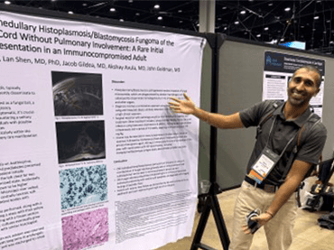 Image of fellow next to their research.