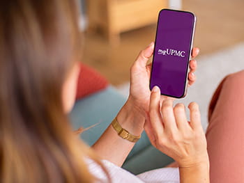 Man laying on couch looking at cellphone.