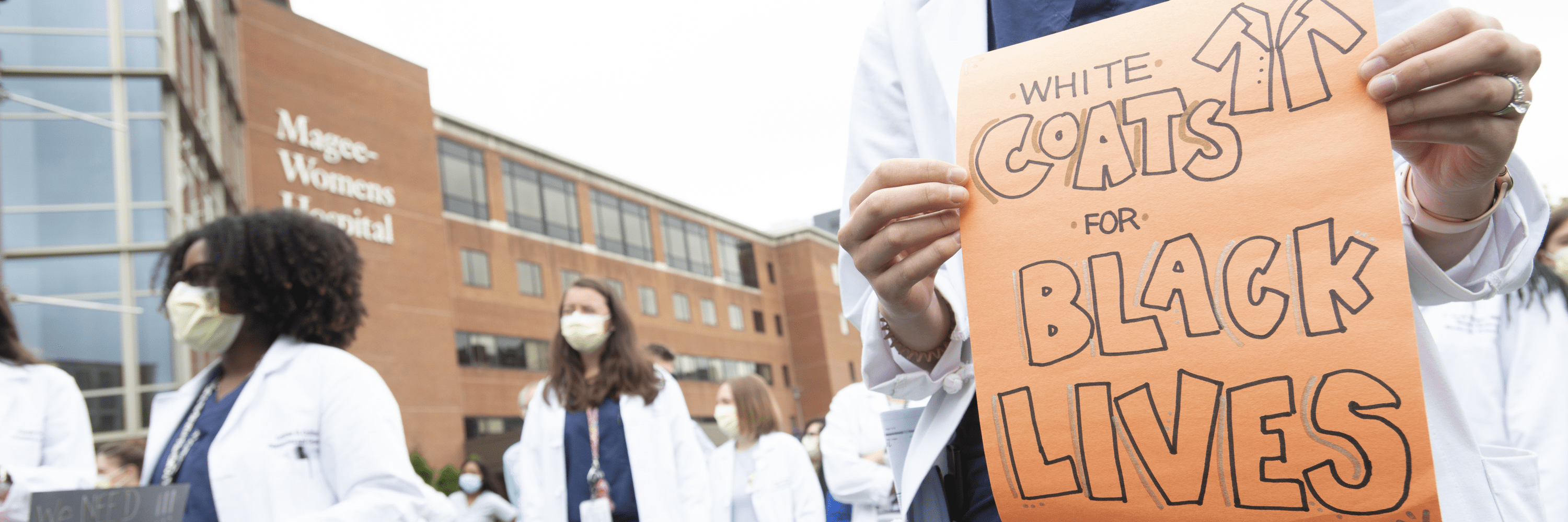 Doctors gather with signs and protest for Black Lives Matter outside Magee-Women's Hospital.