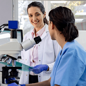 Image of providers talking by microscope.