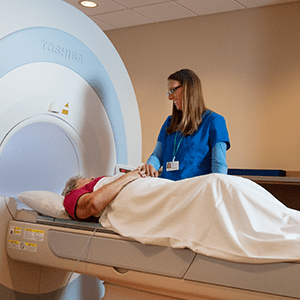 Image of provider with patient getting MRI.