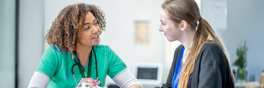 Image of healthcare professional talking to student.