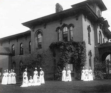 UPMC Chautauqua nurses gather on the lawn of the historic hospital building (circa 1897).