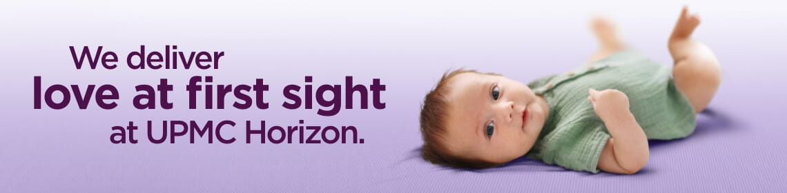 A purple background featuring a picture of a playing baby wearing a green jumper. There is purple text which reads: "We deliver love at first sight at UPMC Horizon."