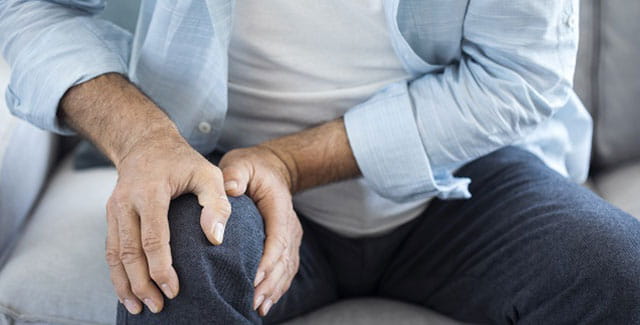 Man holding his knee.