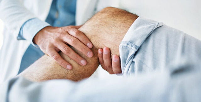 Doctor checking a patients knee.