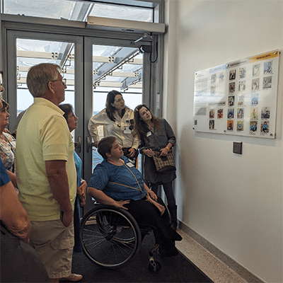  Deborah Aschheim created an image featuring all twenty-five participants for the small vestibule between the garage and entrance to the level 4 reception area. This photo shows people enjoying the group portraits.