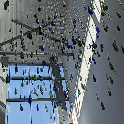 Multicolored bottles hanging from the ceiling. 