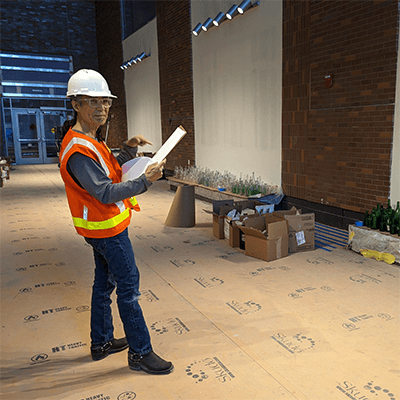 The artist looking at plans as he carefully determines the location for each bottle.