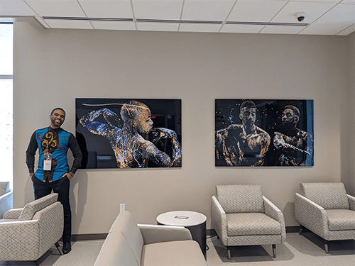 The artist celebrating the installation of his photographs during the opening reception of the facility in April 2023.