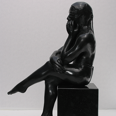 Bronze sculpture of a seated figure with legged crossed.