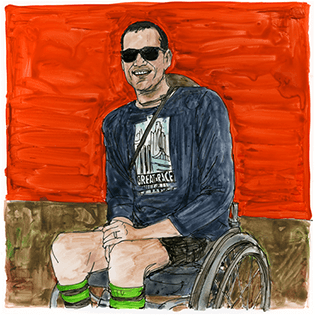 Bryan sits in front of a red wall in a wheelchair.
