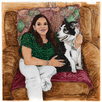 Deidre LaSalvia sits in a chair with her black and white border collie. 