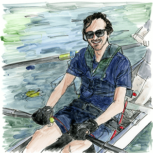 Jackson sits in a boat holding the oars and smiling. 
