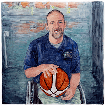 Lee Tempest sits in a wheelchair holding a basketball on his lap.  