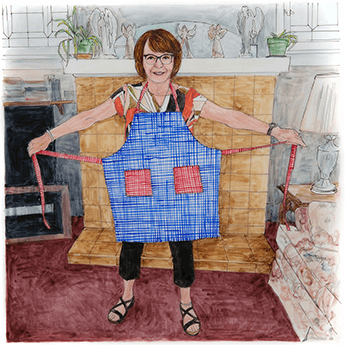 Linda stands in front of a fireplace wearing a blue apron with red pockets. 