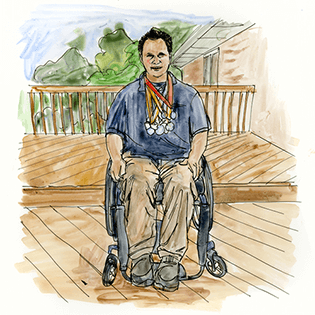 Tom sits outside on a deck in his wheelchair with several medals around his neck. 