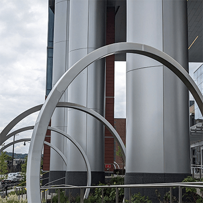 A view of the artwork near the Vision Institute entrance. Steel archways hover over the walkway.