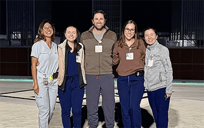 An image of 5 residents enjoying the city view of Pittsburgh while on the night shift.