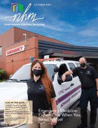 Two members, a woman and a man, of UPMC Passavant's Emergency Services team stand in front of an emergency vehicle, which is parked in front of the emergency department.