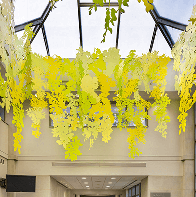 When people arrive at the hospital, they move through an atrium that features a suspended sculpture. The artwork brings the shapes of the trees in the garden painted in vibrant spring colors indoors to foster a welcoming atmosphere.  Photo by Sean Carroll. 