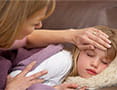 Mom feeling girls forehead for fever