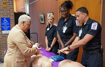 Members of Community LifeTeam EMS teach Mayor Wanda Williams how to perform chest compressions as part of CPR.
