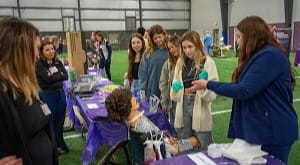 Students are shown how to perform trach care on a dummy by a UPMC nurse at the UPMC High School Career Expo at the Liberty Arena.