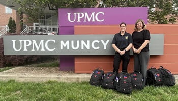Andrea Reed, president, UPMC Muncy, (right) and Cpl. Jennifer McMunn, Pennsylvania State Police, (left) with the six donated emergency response backpacks.