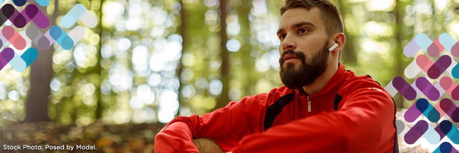 Adult programs banner. Image of man listening to music in woods.