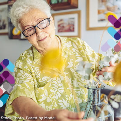 Geriatric services callout. Image of older woman looking at flowers.