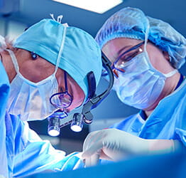 Two surgeons operate in operating room