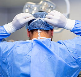 Doctor putting on surgical mask.