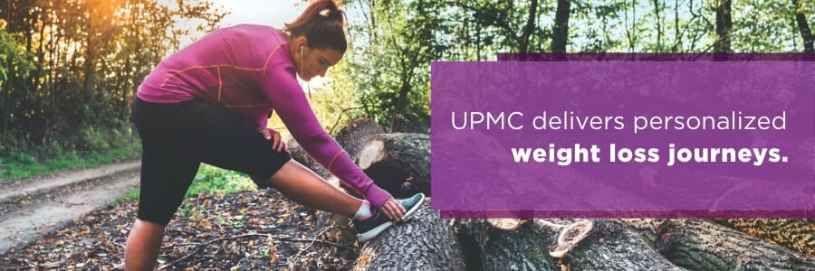 Image of woman stretching her leg in the woods preparing for a run with a banner that reads, UPMC delivers personalized weight loss journeys.