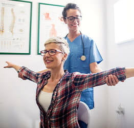 Physical therapist works shows patient exercises
