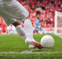 Image of a soccer player kicking a soccer ball.