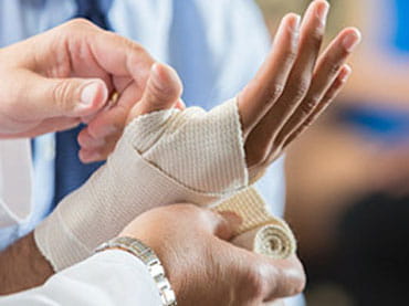 Doctor bandages patient's hand