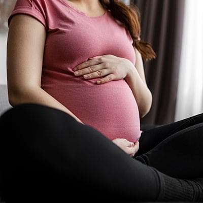 Photo of a woman holding her pregnant stomach.
