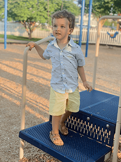 Kai as a toddler playing on a playground