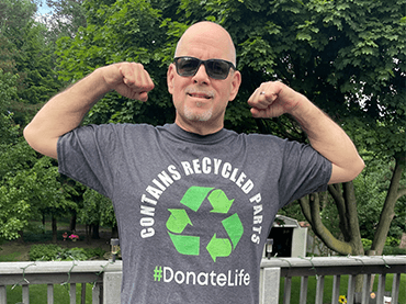 Image of Tim Coles flexing his muscles in a #DonateLife t-shirt. 